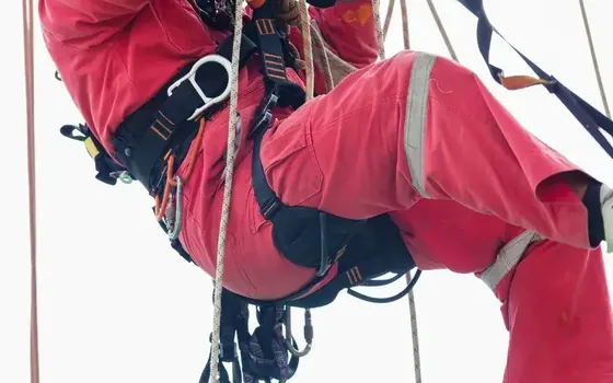 Técnico de acceso por cuerdas instalando una línea de vida en cubierta